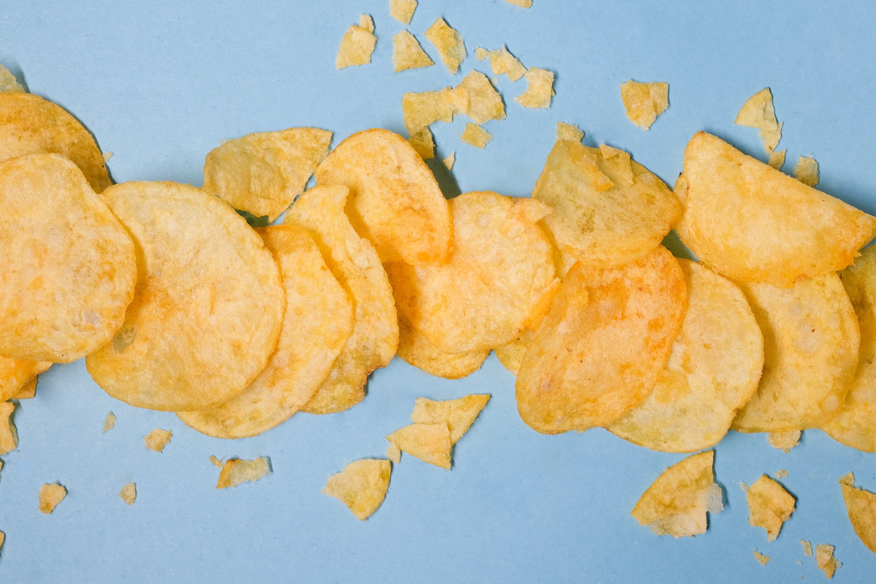potato chips sprinkled across a blue background