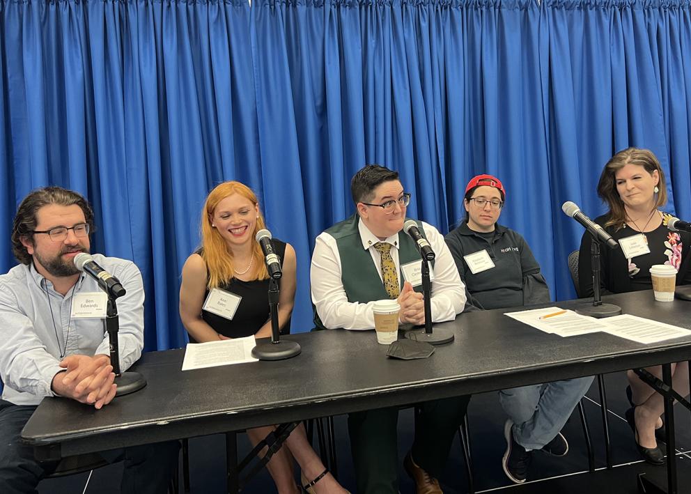 The member sitting at the center of the panel at Autism Across the Life Span reacts with an amused expression to a statement while others seated nearby listen