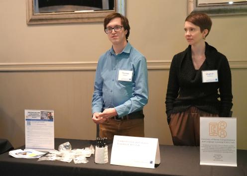 Two people stand at a table displayed with information